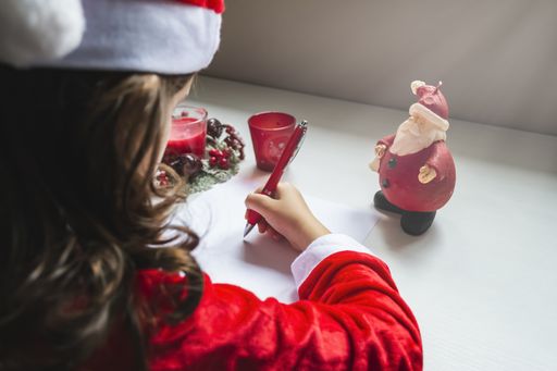 child girl writing letter to santa claus. merry christmas