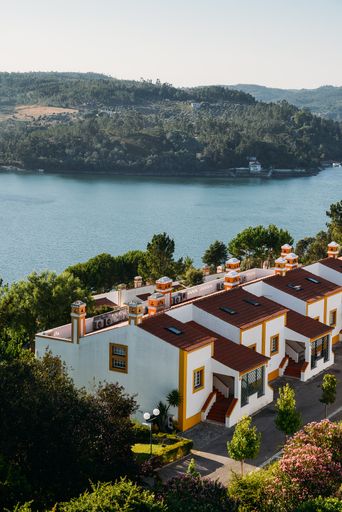 A high angle shot of buildings surrounded by greenery by the sea in Constancia, Santarem, Portugal