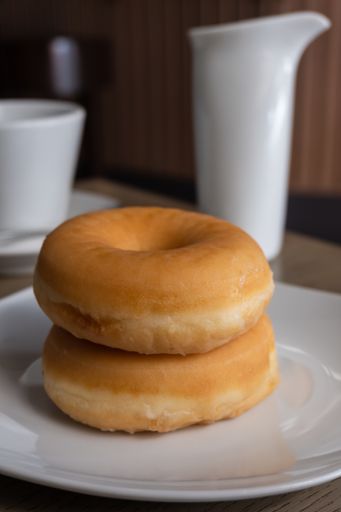 A vertical closeup shot of two fresh donuts on a plate