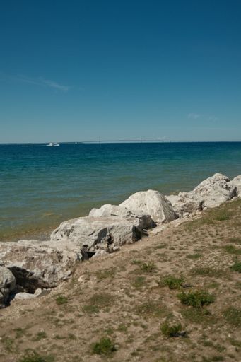 A vertical shot of a rocky beach shore on a sunny day at Mackinac Island, Michigan