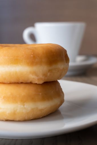 A vertical closeup shot of two fresh donuts on a plate