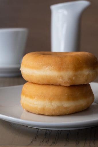 A vertical closeup shot of two fresh donuts on a plate