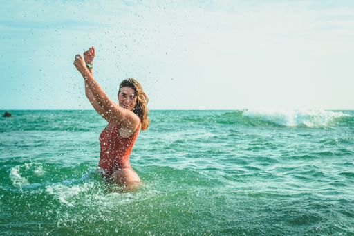 A beautiful European female with an orange swimsuit having fun at sea