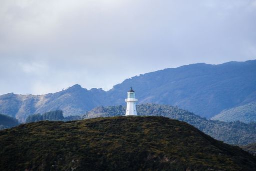 A lonely tower on the top of a green hill
