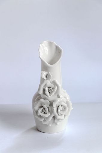 A vertical shot of a white porcelain decorative flower vase isolated on a white background
