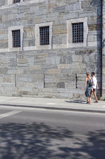 A couple walking in front of a historic building in Uskudar Istanbul, turkey