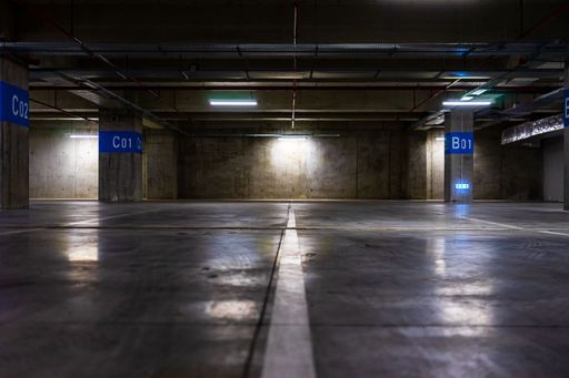A symetrical view of an empty parking lot at an underground parking garage, with lights