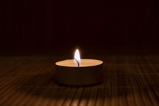 A closeup of a burning candle in the dark