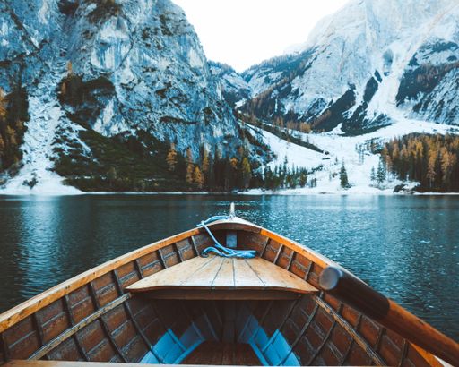 A closeup shot of a wooden boat near the mountains in winter