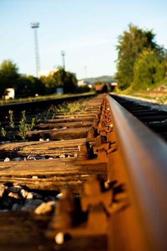 A vertical shot of old wooden railways in a rural area in sunny weather on a blurred background