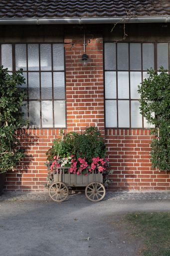 A vertical shot of a loft with flowers against a bricked wall background