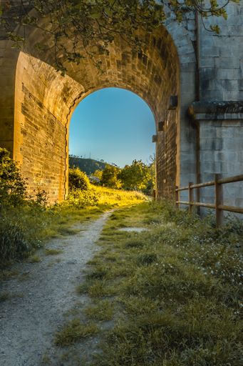 A vertical shot of a dirt road passing under the bridge in Ribas de Sil, located in Galicia, Spain