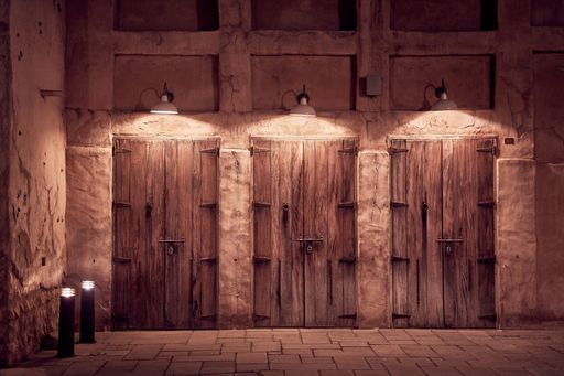 An amazing shot of ancient Arabic wooden doors illuminated by lamps at night