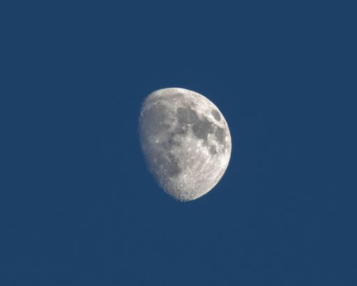A closeup of moon in blue sky