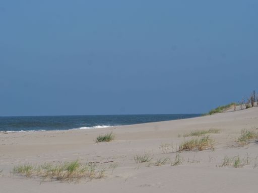 A beautiful sandy beach at Juist island in Germany with the North Sea and a in the background