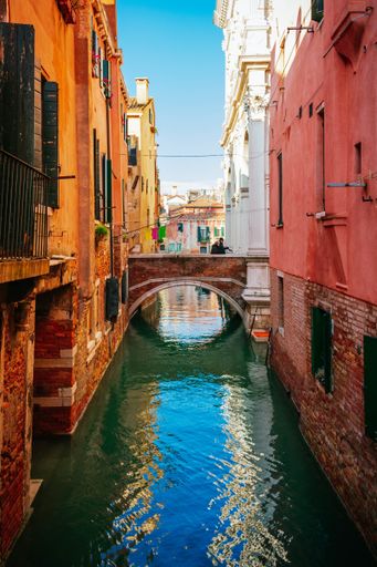 Two seniors walking among the canals of venice