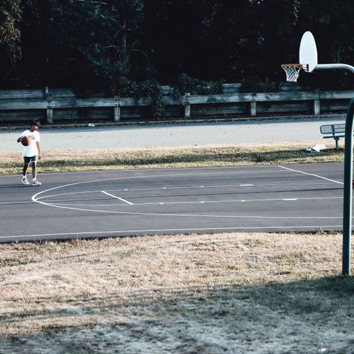 A young boy playing in a basketball court in Warwick, New York, USA