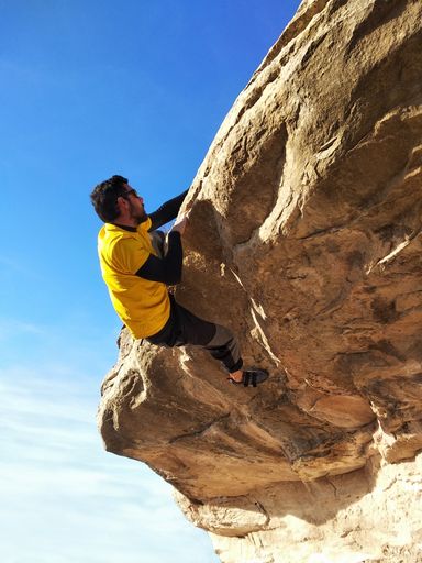 Man climbing a high rock in the mountains. Concept of adventure and extreme sport