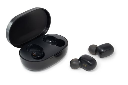 Wireless black bluetooth earphones with contactless charging isolated close-up on a white background