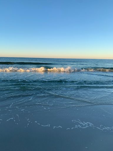 A vertical shot of sea waves against the background of the bluesky.