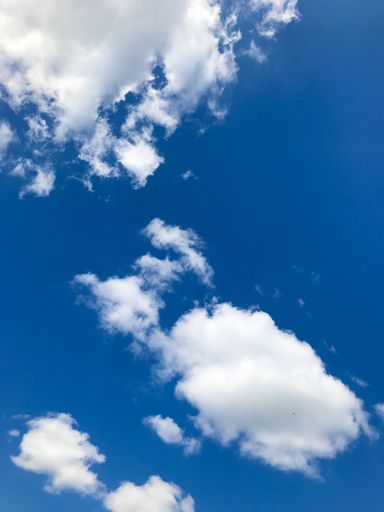 A low angle shot of a blue cloudy sky at daytime - perfect for wallpapers