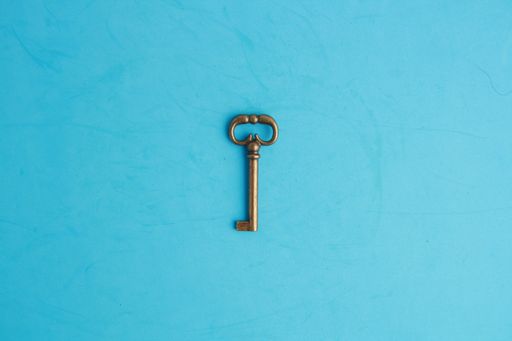 A top view of a vintage key on a blue surface