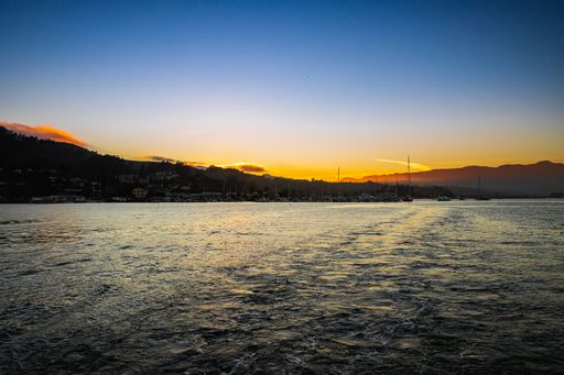 A scenic shot of the coast of San Francisco with the silhouette of the city during dusk