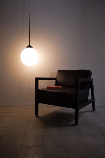 A minimalistic interior with black  and glowing bulb