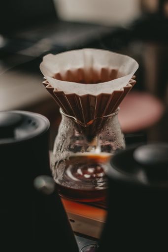 A soft focus of a pour over coffee set-up using cone dripper and glass decanter
