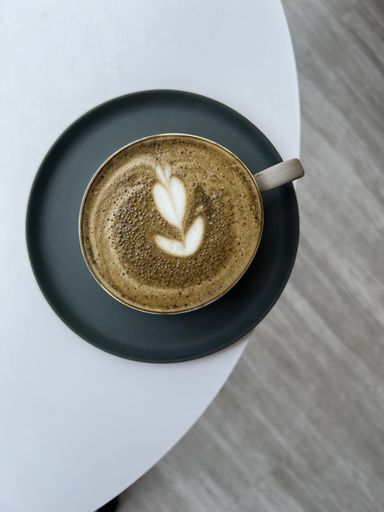 A top view of a cup of coffee with milk and a beautiful latte art of a tulip