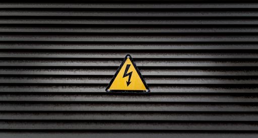 A yellow danger sign on a black striped wall