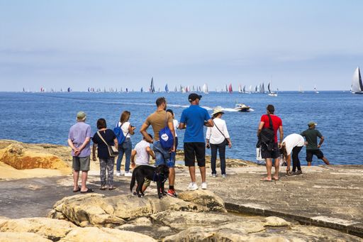 Spectators watching and photographing the Rolex Middle Sea Yacht Race from shore of Grand Harbour, Malta, Mediterranean