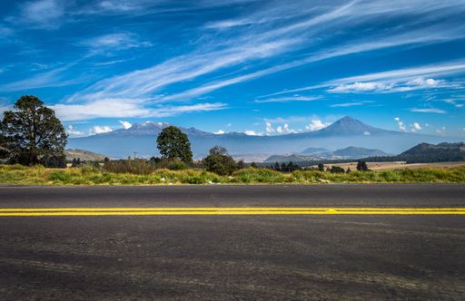 An empty road on mountain background under blue sky