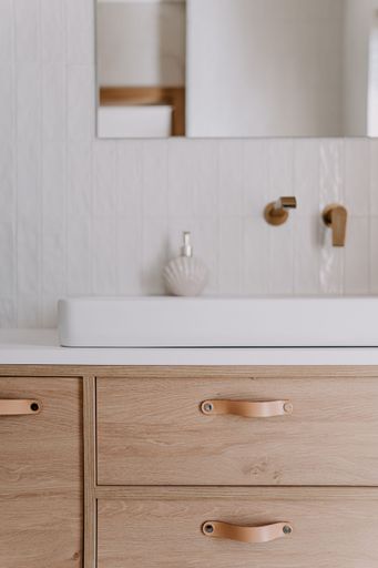 A modern bathroom featuring a white porcelain sink in front of a large mirror