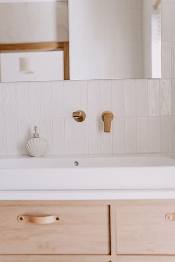 A modern bathroom featuring a white porcelain sink in front of a large mirror