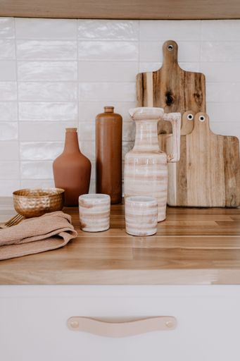 A rustic kitchen countertop with a selection of ceramic pots and bowls on display