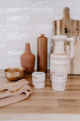 A rustic kitchen countertop with a selection of ceramic pots and bowls on display