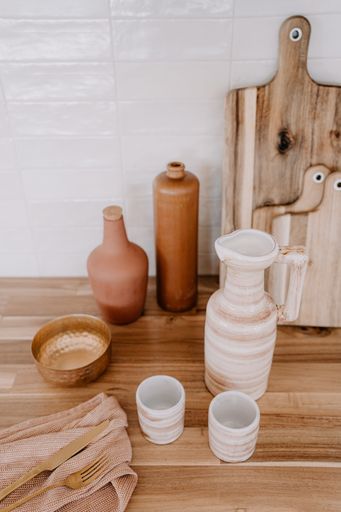 A rustic kitchen countertop with a selection of ceramic pots and bowls on display