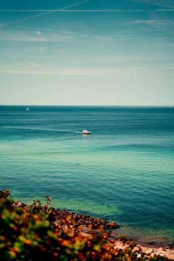 A vertical shot of a boat sailing in a tranquil sea