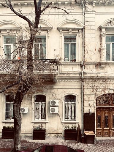 A vertical shot of old residential, ornamental building with balconies