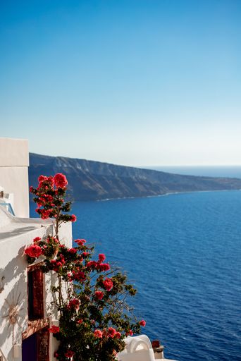 A vertical shot of white building at shore in Santorini, Greece