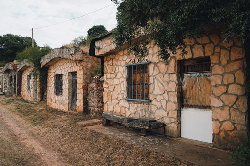 An old abandoned stone house with grass growing on the roof