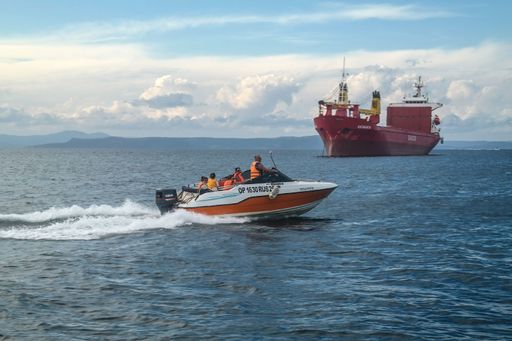 A speed boat and a freight ship in the vicinity of Russian sea port of Vladivostok