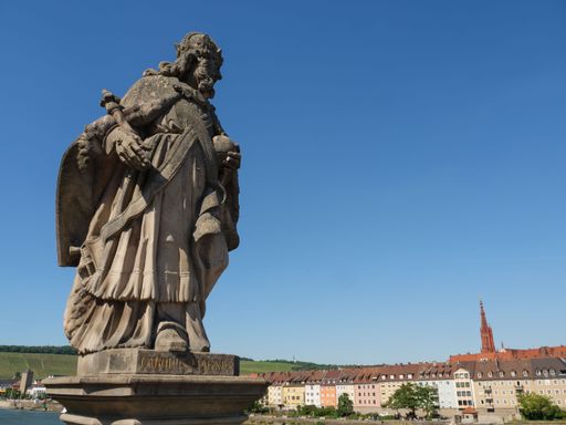 A statue of Charlemagne on the background of buildings under the blue sky in Wuerzburg, Germany