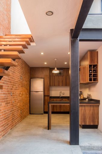 a modern wooden kitchen with black bar and tile backsplash
