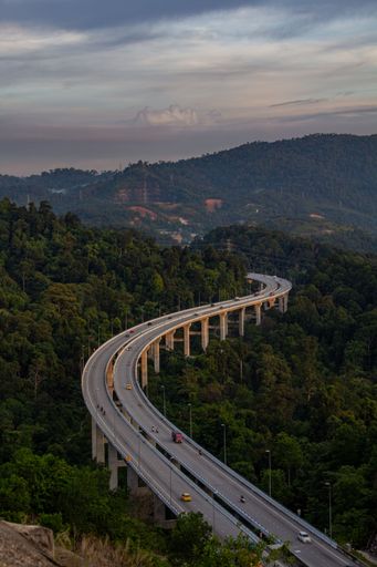 A vertical shot of Rawang Bypass highway amid green forest with dense trees in Malaysia