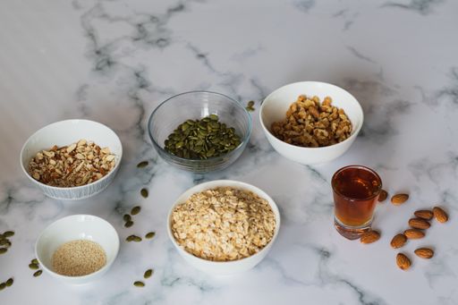A closeup shot of bowls with healthy ingredients for oatmeal cookies on a kitchen table