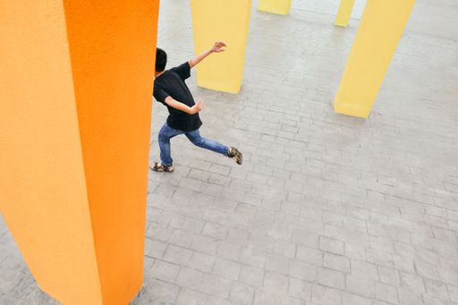 A boy running between yellow columns