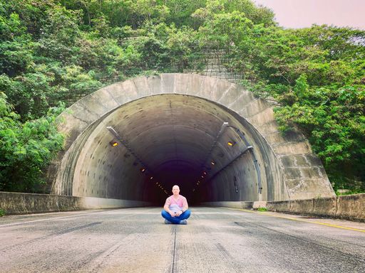 A Hispanic man sitting on the road in front of a tunnel in Puerto Rico