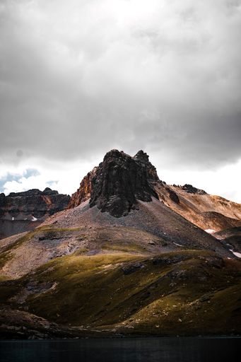 A  beautiful view of rocky cliffs and yellow hills under huge gray clouds on a gloomy day in the wilderness